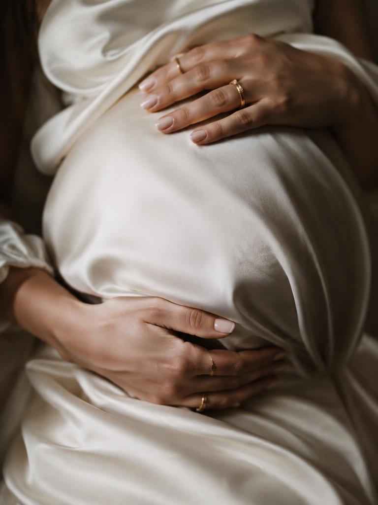 Hands with gold rings on ivory silk