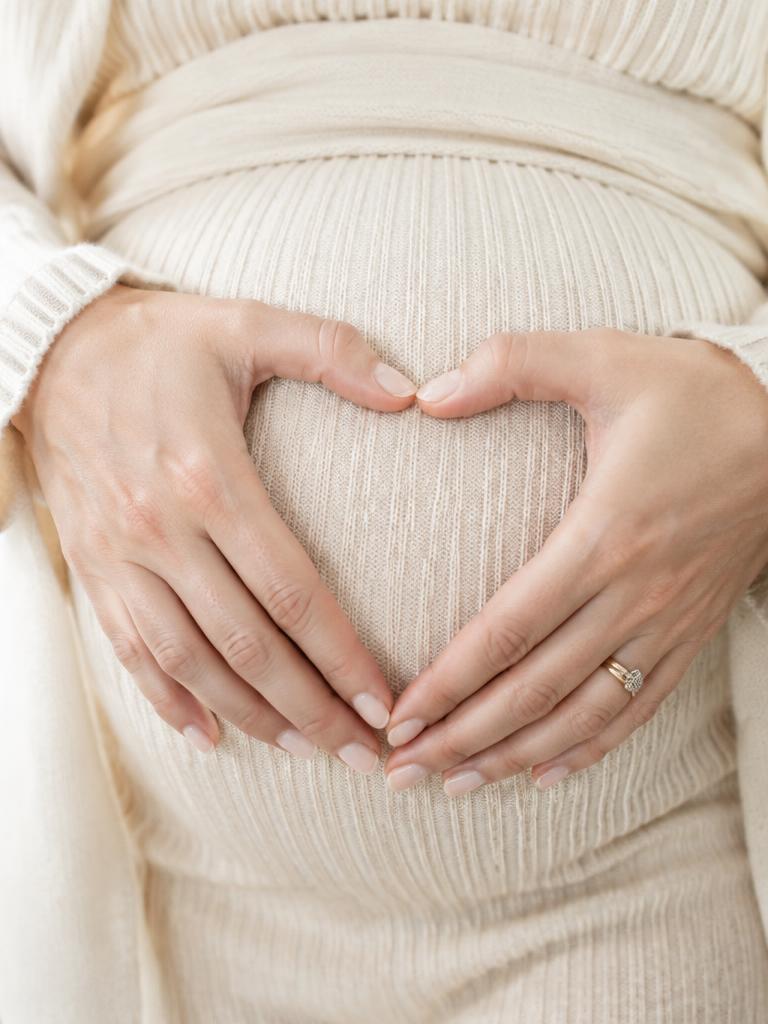 Hands forming a heart on the bump